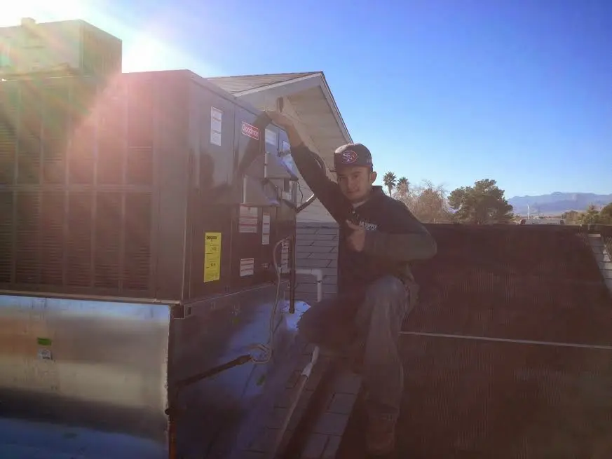 HVAC technician performing AC Tune-Up on a rooftop unit in Barnstable Town